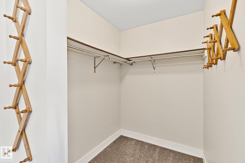 The property features an L-shaped closet with shelving and hanging rods, complemented by a carpeted floor - 10823 130 Street, Edmonton, AB - Indoor Photo Showing Other Room