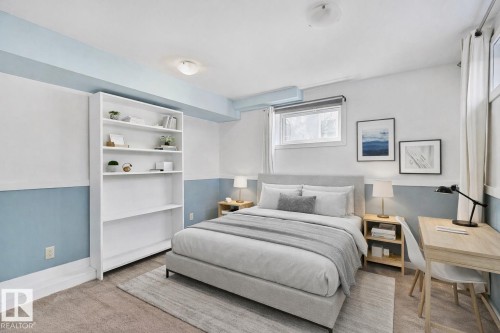 Inviting room featuring a window with white curtains, a white built-in bookshelf, and light-colored carpeting - 10823 130 Street, Edmonton, AB - Indoor Photo Showing Bedroom