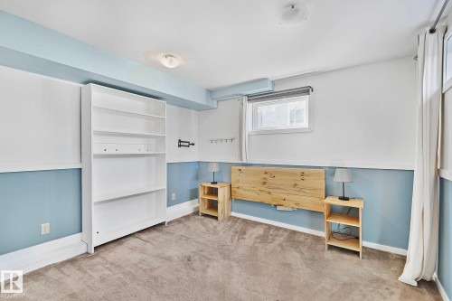 This room features light blue and white walls, a window with curtains, and carpeted flooring - 10823 130 Street, Edmonton, AB - Indoor
