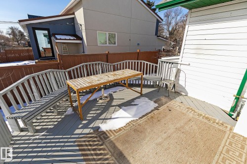 The property features an outdoor deck with light gray decking and a matching bench, complemented by a wooden outdoor table - 10823 130 Street, Edmonton, AB - Outdoor With Exterior