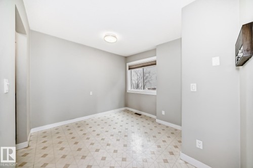 Neutral-toned room featuring light gray walls, a window with horizontal blinds, and patterned tile flooring - 2709 124 Street, Edmonton, AB - Indoor Photo Showing Other Room