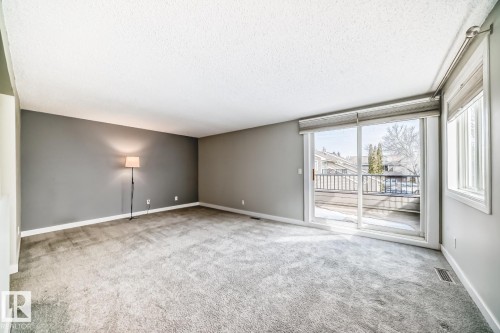 Living area featuring neutral gray walls, light gray carpet flooring, and white baseboards - 2709 124 Street, Edmonton, AB - Indoor Photo Showing Other Room