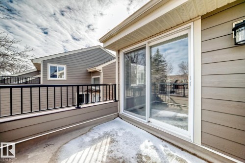 Private outdoor deck with concrete surface, black metal railing, and sliding glass door access - 2709 124 Street, Edmonton, AB - Outdoor With Deck Patio Veranda With Exterior