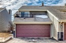 Two-car garage with a paneled door, stone veneer accents, and an upper-level balcony with a black metal railing - 2709 124 Street, Edmonton, AB  - Outdoor With Exterior 