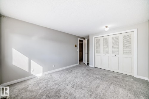Room featuring light gray walls, gray carpeting, white baseboards, and white bi-fold closet doors - 2709 124 Street, Edmonton, AB - Indoor Photo Showing Other Room