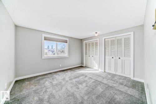 Spacious room featuring gray textured carpeting, a white ceiling, and light gray walls - 2709 124 Street, Edmonton, AB - Indoor Photo Showing Other Room