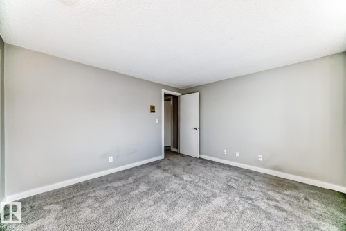 Spacious interior room featuring light gray wall paint, white trim, and gray carpet flooring - 2709 124 Street, Edmonton, AB - Indoor Photo Showing Other Room
