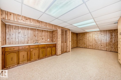 Room featuring wood-finish wall paneling and a drop ceiling with integrated lighting - 2709 124 Street, Edmonton, AB - Indoor