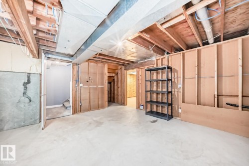 Unfinished basement space featuring exposed wood framing, concrete flooring, and visible HVAC ductwork - 2709 124 Street, Edmonton, AB - Indoor Photo Showing Basement