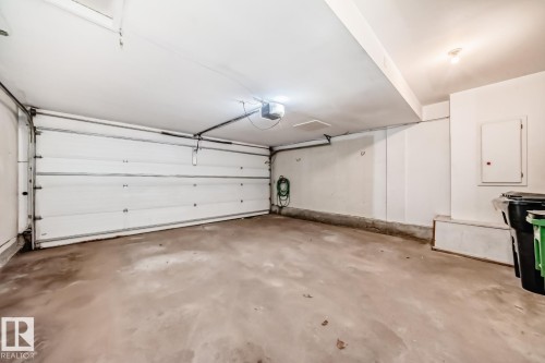 Spacious garage featuring a concrete floor, overhead lighting, and an automatic garage door opener - 2709 124 Street, Edmonton, AB - Indoor Photo Showing Garage