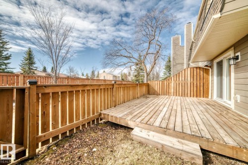 Private wood deck with a built-in privacy wall, offering direct outdoor access through a sliding glass door - 2709 124 Street, Edmonton, AB - Outdoor With Deck Patio Veranda