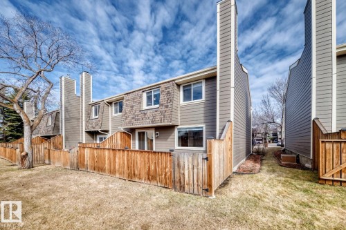 Exterior of a multi-level townhome featuring dormer windows, a sliding glass door, and vertical siding - 2709 124 Street, Edmonton, AB - Outdoor