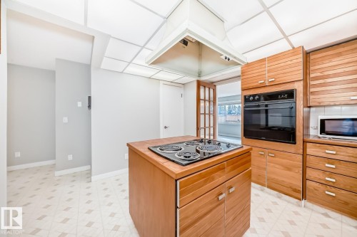 Central kitchen island with an electric cooktop - 2709 124 Street, Edmonton, AB - Indoor Photo Showing Kitchen