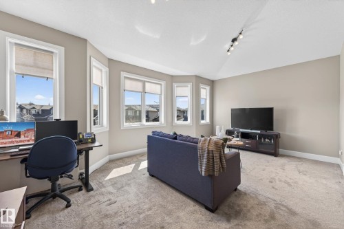 Carpeted room with multiple windows, track lighting, and neutral wall tones - 2086 Redtail Common, Edmonton, AB - Indoor