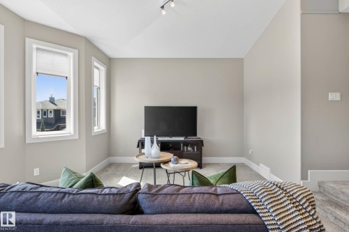 Bright living area featuring neutral wall tones, multiple windows, recessed lighting, and carpet flooring - 2086 Redtail Common, Edmonton, AB - Indoor Photo Showing Living Room