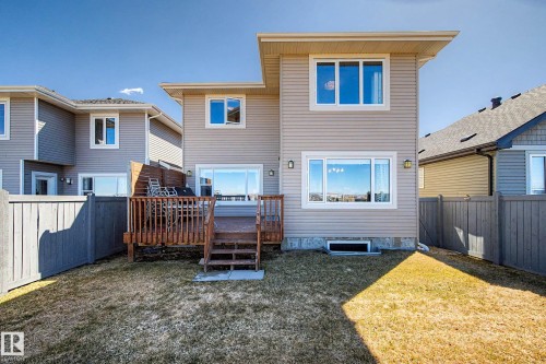 Rear exterior featuring a spacious wood deck with steps, privacy fencing, and a ground-level yard - 2086 Redtail Common, Edmonton, AB - Outdoor