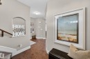 Hardwood-finish flooring extending through the hallway, complemented by light neutral wall tones and bright white trim - 2086 Redtail Common, Edmonton, AB  - Indoor Photo Showing Other Room 