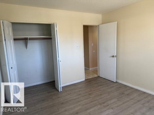 This room features wood-look flooring and light-colored walls - 201 10811 115 Street, Edmonton, AB - Indoor Photo Showing Other Room