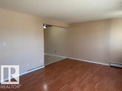Spacious interior featuring wood flooring and light-toned walls - 