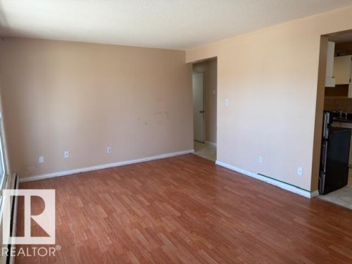 Living area featuring wood-look flooring and light-colored walls - 201 10811 115 Street, Edmonton, AB - Indoor Photo Showing Other Room