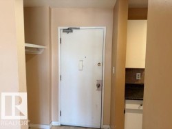 Entryway featuring a white door with a door closer and a built-in shelf - 