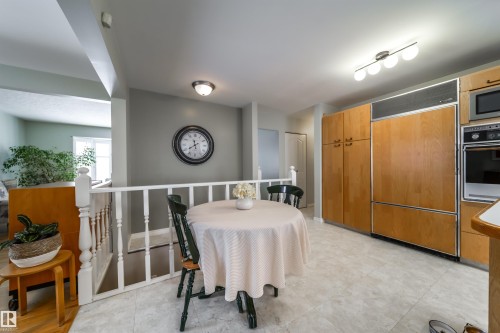 Kitchen with light wood-finish cabinetry, built-in wall oven, built-in microwave, and tile flooring - 10231 46 Street, Edmonton, AB - Indoor Photo Showing Other Room