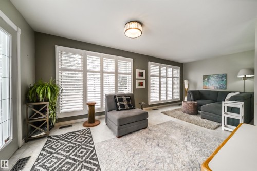 Living area with light-colored flooring and dark accent walls - 10231 46 Street, Edmonton, AB - Indoor Photo Showing Living Room