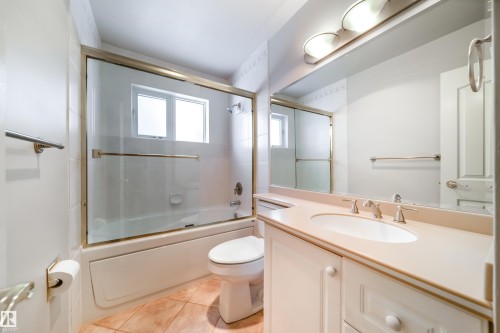 Bathroom featuring a vanity with an integrated sink, a rectangular mirror, and an overhead light fixture - 10231 46 Street, Edmonton, AB - Indoor Photo Showing Bathroom