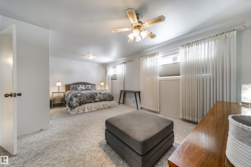Spacious room featuring light-toned carpeting, white walls, and a ceiling fan with integrated lighting - 10231 46 Street, Edmonton, AB - Indoor Photo Showing Bedroom