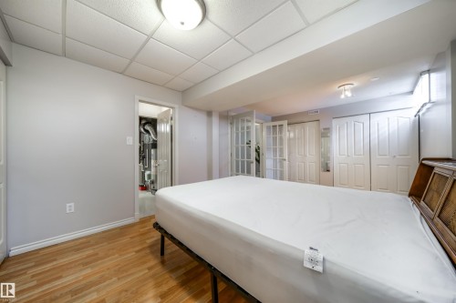 Wood-finish flooring with white baseboards - 10231 46 Street, Edmonton, AB - Indoor Photo Showing Other Room