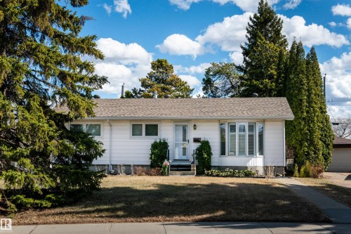 White exterior residence with a front lawn and paved driveway - 10231 46 Street, Edmonton, AB - Outdoor With Facade