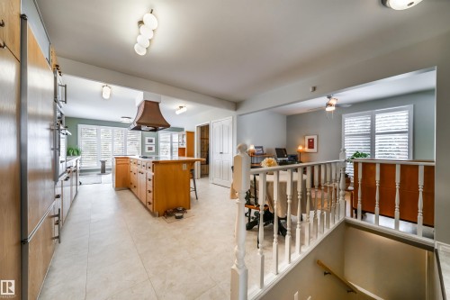 Kitchen featuring wood cabinetry, integrated appliances, and a central island with a wood-finish countertop - 10231 46 Street, Edmonton, AB - Indoor Photo Showing Other Room