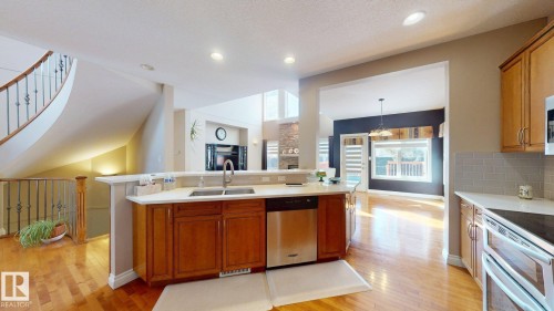 The property features a kitchen with a double basin sink, stainless steel dishwasher, and wooden cabinetry - 613 Todd Link, Edmonton, AB - Indoor Photo Showing Kitchen With Double Sink With Upgraded Kitchen
