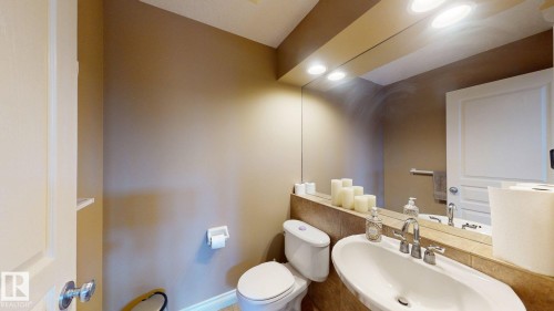 Bathroom featuring a vanity with an integrated sink and a large mirror with integrated lighting - 613 Todd Link, Edmonton, AB - Indoor Photo Showing Bathroom
