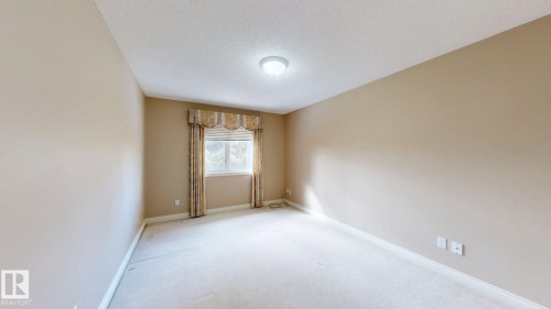 Spacious room with carpeted flooring, neutral-toned walls, and a window providing natural light - 613 Todd Link, Edmonton, AB - Indoor Photo Showing Other Room
