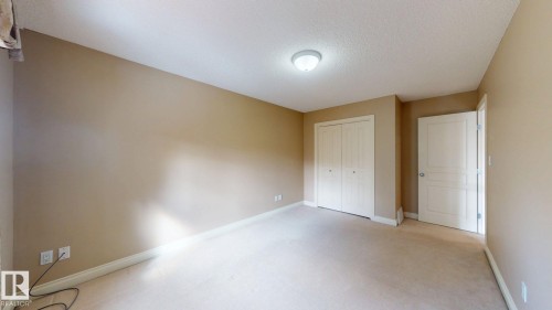 This room features neutral-toned walls, carpeted flooring, and a ceiling light fixture - 613 Todd Link, Edmonton, AB - Indoor Photo Showing Other Room