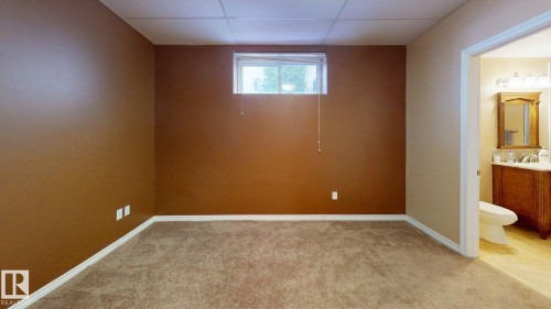 This room features neutral-toned carpet flooring and a window providing natural light - 613 Todd Link, Edmonton, AB - Indoor Photo Showing Other Room