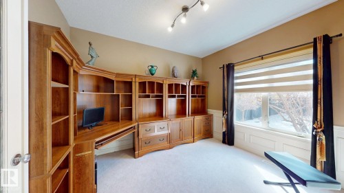 This room features extensive built-in wooden shelving and desk space, ideal for organization - 613 Todd Link, Edmonton, AB - Indoor