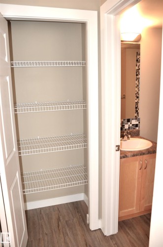 Pantry featuring wire shelving and wood-finish flooring - 103 920 156 Street Nw, Edmonton, AB - Indoor With Storage