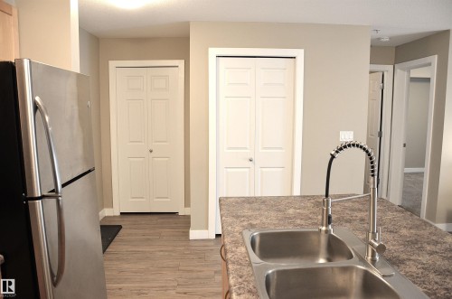 Kitchen island with a double basin stainless steel sink and a gooseneck faucet - 103 920 156 Street Nw, Edmonton, AB - Indoor Photo Showing Kitchen With Double Sink