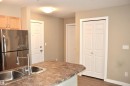 Kitchen island featuring a double basin stainless steel sink with a high-arc pull-down faucet - 103 920 156 Street Nw, Edmonton, AB  - Indoor Photo Showing Kitchen With Double Sink 