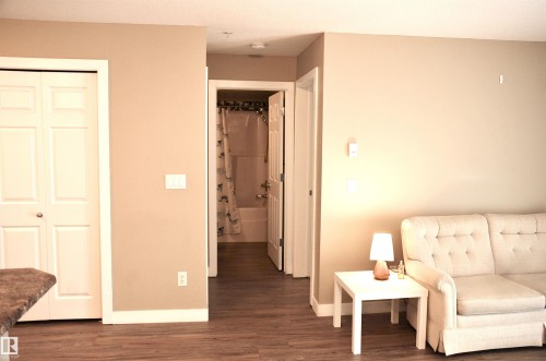 Wood-finish flooring throughout, complemented by light neutral wall tones and white trim - 103 920 156 Street Nw, Edmonton, AB - Indoor