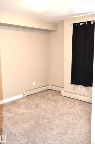 Neutral-toned carpet flooring complementing beige wall paint - 103 920 156 Street Nw, Edmonton, AB - Indoor Photo Showing Other Room
