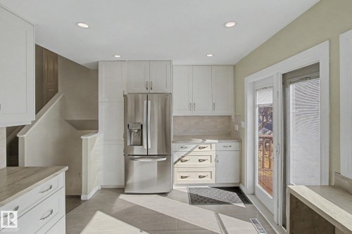 Kitchen featuring white cabinetry, stainless steel French door refrigerator, light-toned countertops, and recessed lighting - 3903 32 Street, Edmonton, AB - Indoor Photo Showing Kitchen
