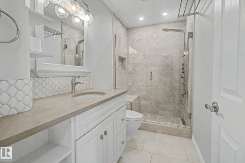 Bathroom featuring a white vanity with built-in storage, a light-toned countertop, and a contemporary sink with brushed nickel hardware - 3903 32 Street, Edmonton, AB - Indoor Photo Showing Bathroom