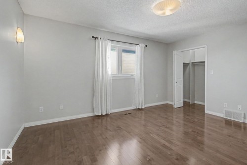 Hardwood flooring throughout a spacious room with a double-door closet - 3903 32 Street, Edmonton, AB - Indoor Photo Showing Other Room