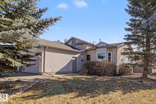 Exterior featuring light-toned horizontal siding, a multi-pane bay window, and an attached two-car garage - 3903 32 Street, Edmonton, AB - Outdoor