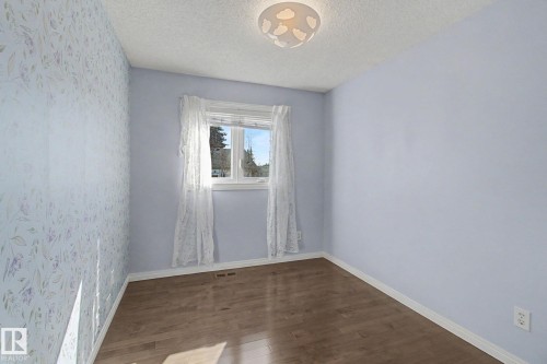 Room featuring wood-finish flooring, a single window, and a ceiling-mounted light fixture - 3903 32 Street, Edmonton, AB - Indoor Photo Showing Other Room