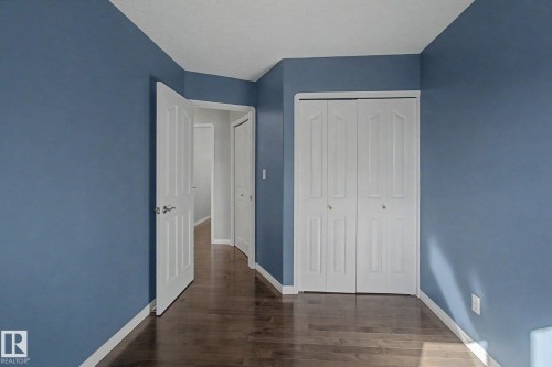 Interior room with wood-finish flooring and a two-panel bifold closet door - 3903 32 Street, Edmonton, AB - Indoor Photo Showing Other Room