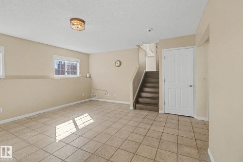 Spacious room featuring tile flooring, light neutral-toned walls, and multiple windows - 3903 32 Street, Edmonton, AB - Indoor Photo Showing Other Room